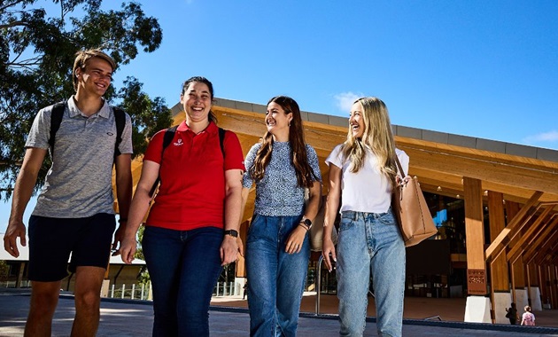 Group of students walking with Boola Katijin building in the background